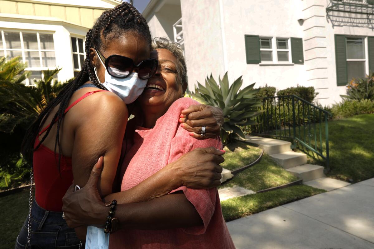  Crystal Bright, right, receives a hug from her sister Vanessa Smith-Robinson in front of Bright's home,