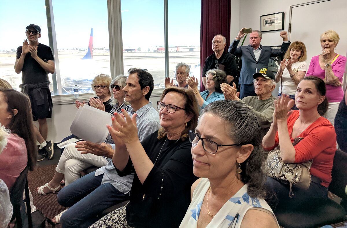 Residents clap during a public meeting