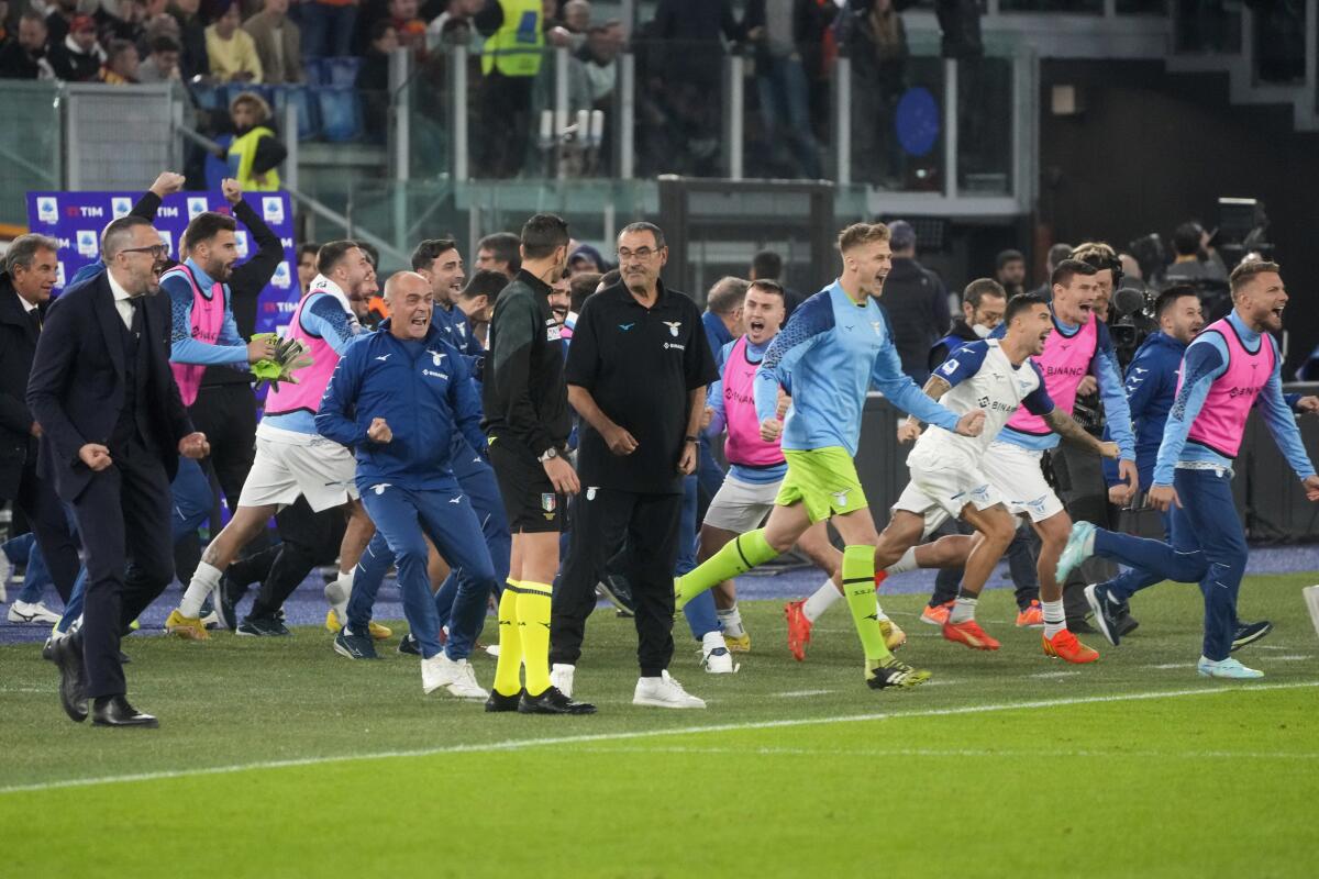 Lazio's head coach Maurizio Sarri, center, celebrates with his players at the end of a Serie A soccer match between Roma and Lazio, at Rome's Olympic Stadium, Sunday, Nov. 6, 2022. (AP Photo/Gregorio Borgia)