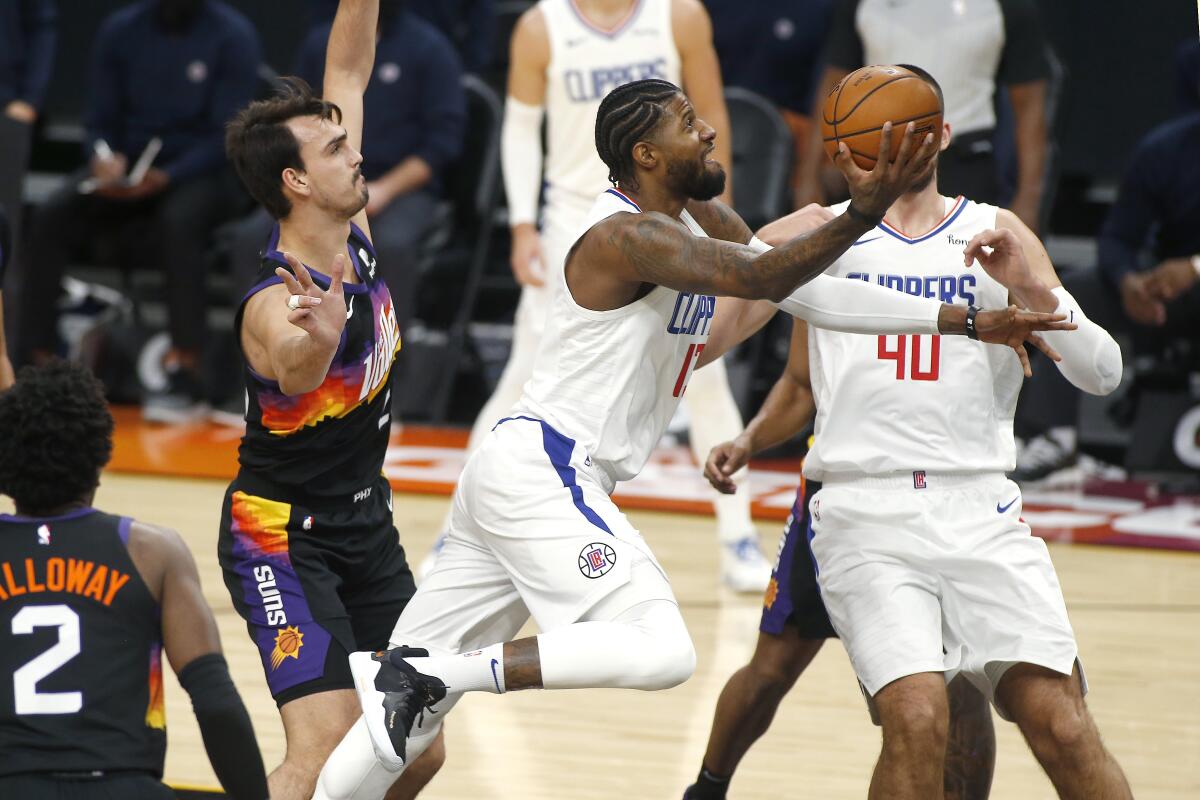 Clippers forward Paul George drives to the basket against the Suns on Jan. 3, 2021, in Phoenix.