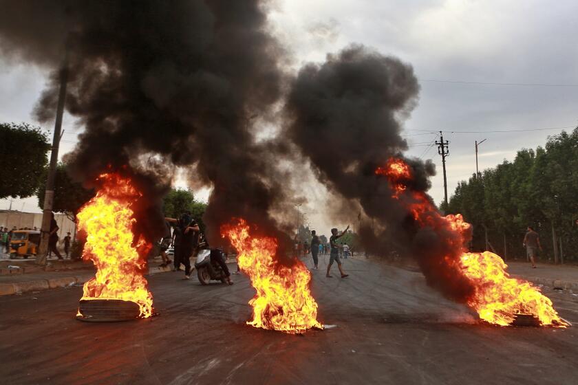 Anti-government protesters set fires and close a street during a demonstration in Baghdad, Sunday, Oct. 6, 2019. Iraqi officials said Sunday 96 protesters and eight security members were killed in nearly a week of unrest, denying government forces clashed or targeted any of the demonstrators. (AP Photo/Khalid Moh