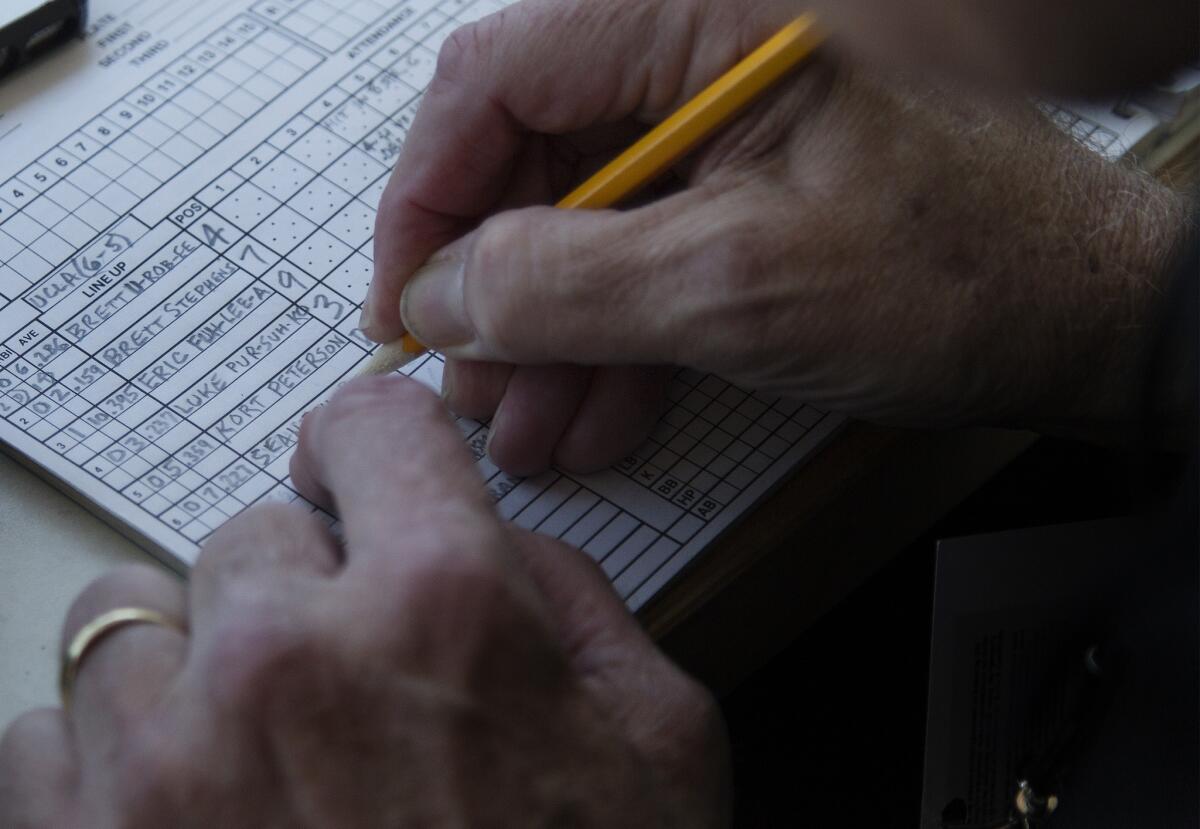 Ross Porter enters the lineups into his scorebook for a game between Cal State Northridge and UCLA.