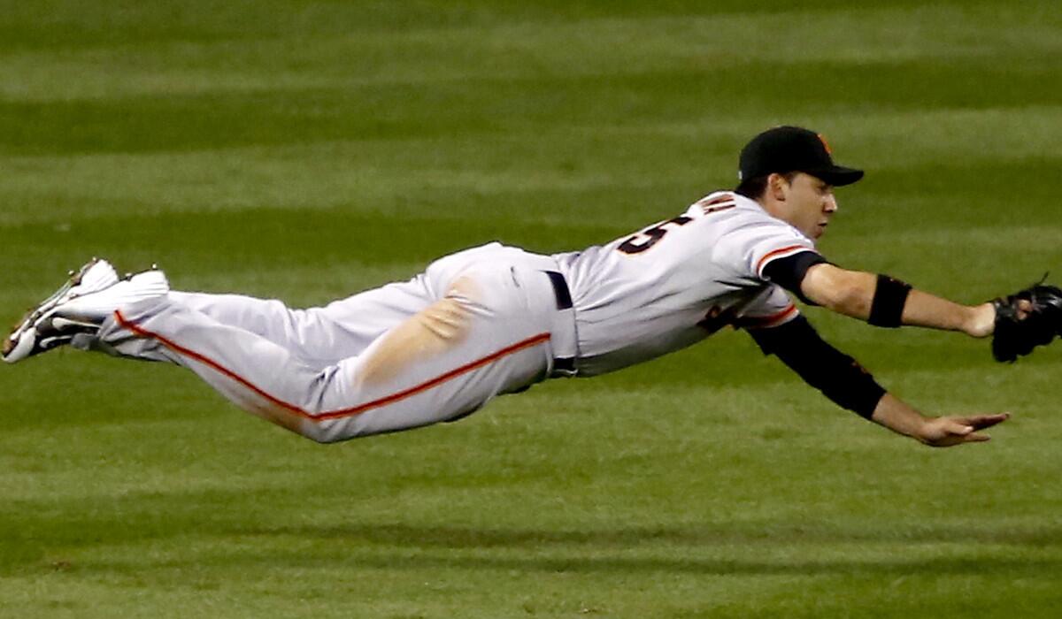 Giants left fielder Travis Ishikawa makes a diving catch on a ball hit by Cardinals catcher Yadier Molina during the fourth inning of Game 1 in the NLCS on Saturday.