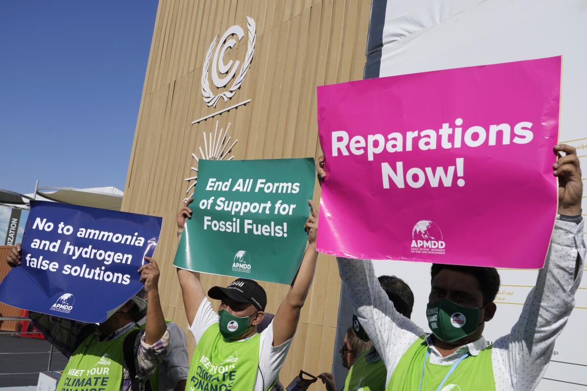 Demonstrators holding up signs at the global climate summit in Egypt