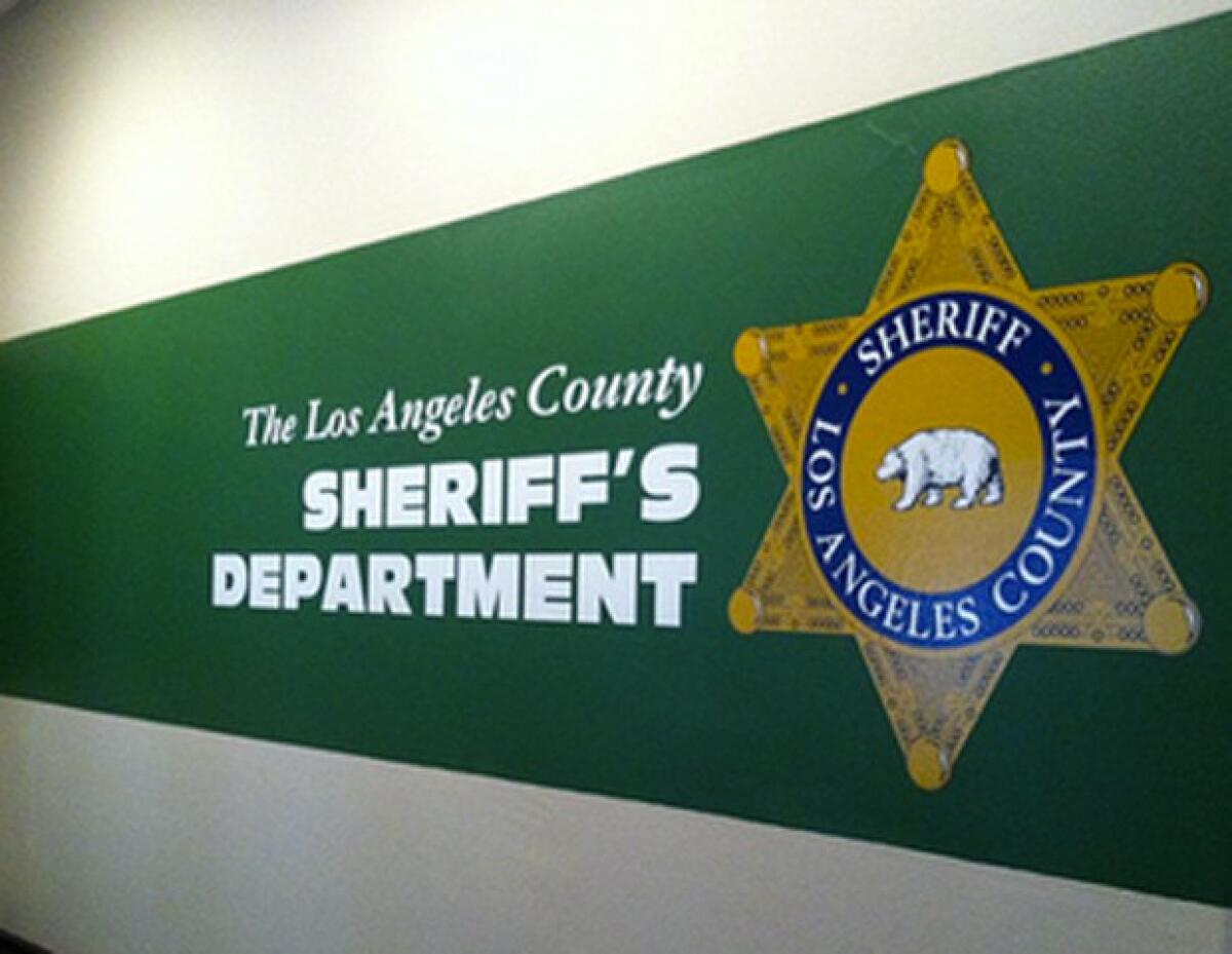 A sign for the Los Angeles County Sheriff's Department painted on a wall
