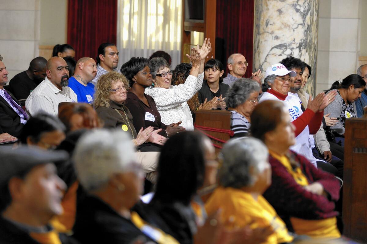 Supporters of a minimum wage increase in Los Angeles applaud a speaker during a City Council committee hearing at City Hall on May 13.