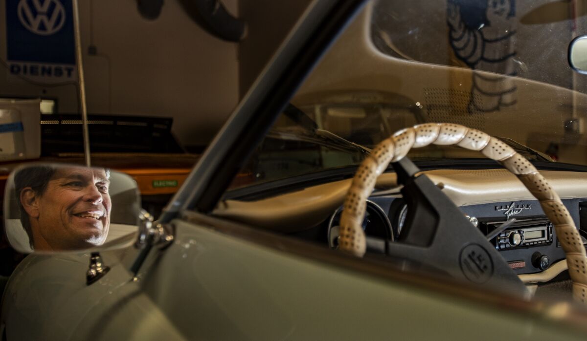 Le visage de Michael Bream, propriétaire d'EV West, se reflète dans le miroir d'une Karmann Ghia.
