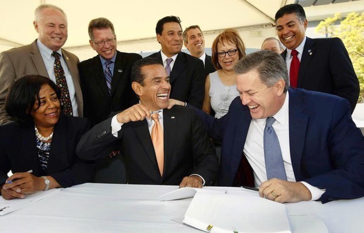 Los Angeles Mayor Antonio Villaraigosa, middle, jokes with AEG President Tim Leiweke, right, as Councilwoman Jan Perry, left, looks on during the signing of agreements to take the next step in landing Los Angeles an NFL team.