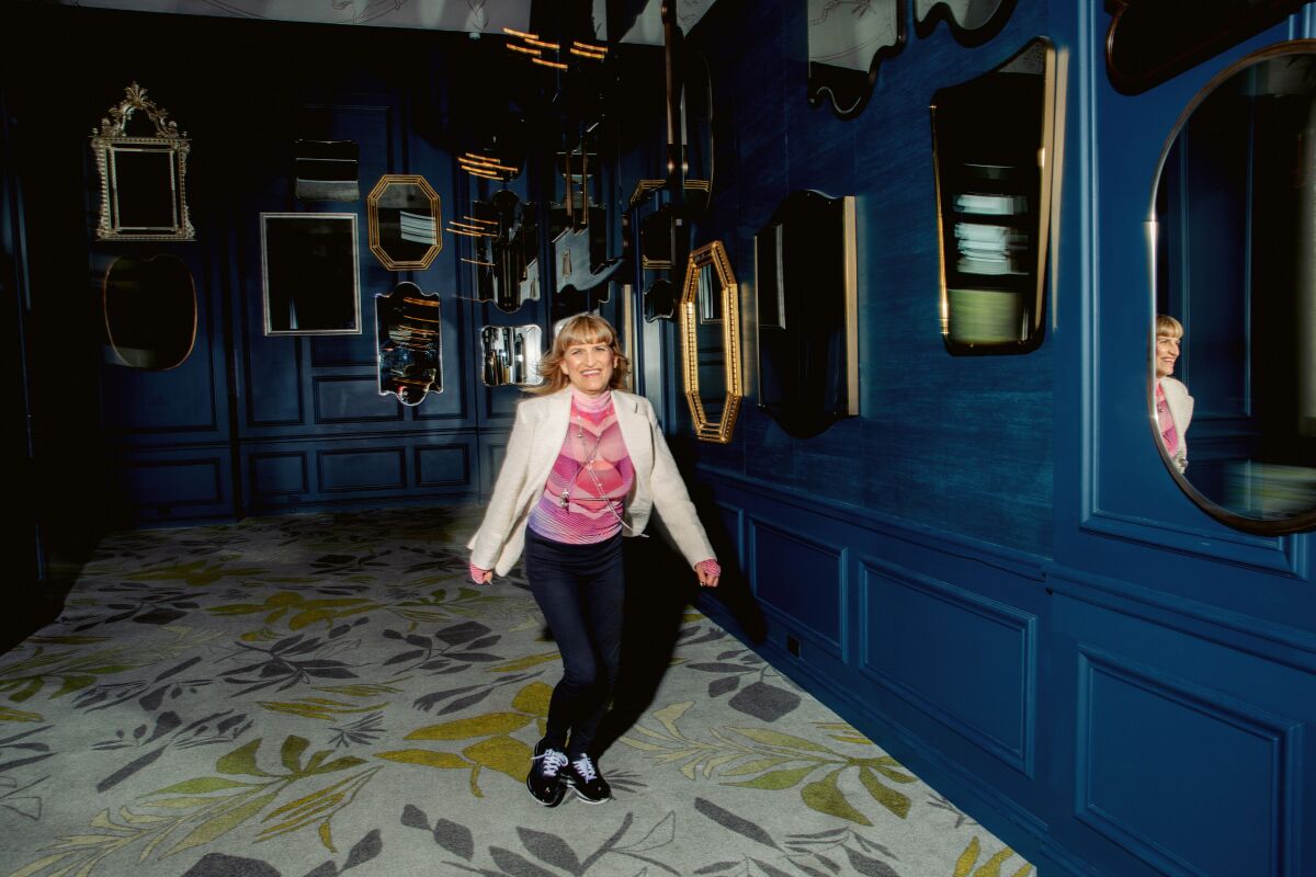Catherine Hardwicke in a room with blue walls covered with mirrors.