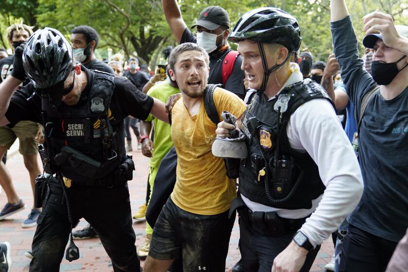 Policías uniformados del Servicio Secreto detienen a un manifestante en Lafayette Park, frente a la Casa Blanca, durante una protesta por la muerte de George Floyd a manos de la policia, el viernes, 29 de mayo del 2020. (AP Foto/Evan Vucci)