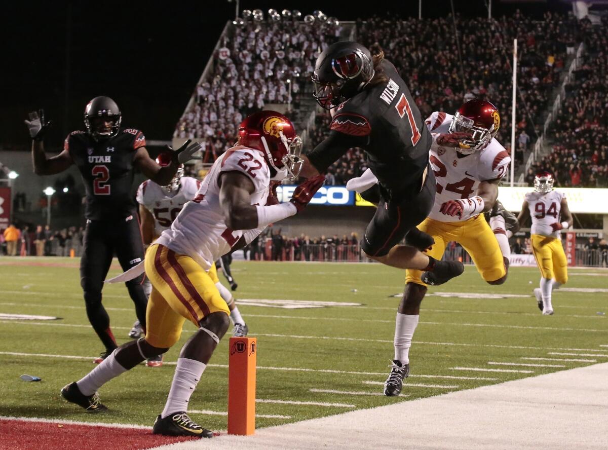 Utah quarterback Travis Wilson leaps toward the goal line but USC defensive backs Leon McQuay III (22) and John Plattenburg (24) would prevent him from scoring in the final minute of the game. The Utes would score the eventual winning touchdown two plays later.