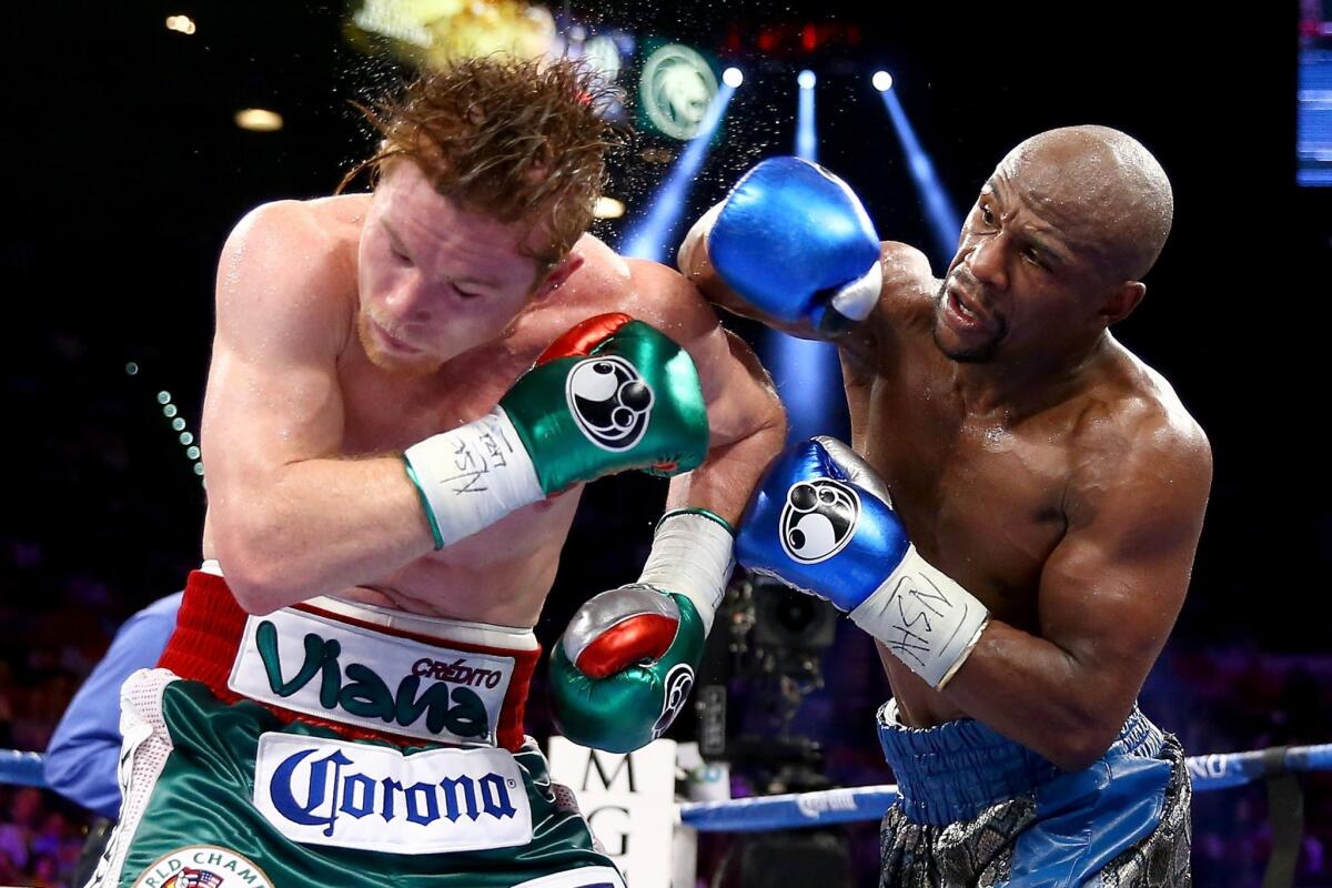 Floyd Mayweather Jr., right, lands a right to the head of Canelo Alvarez.