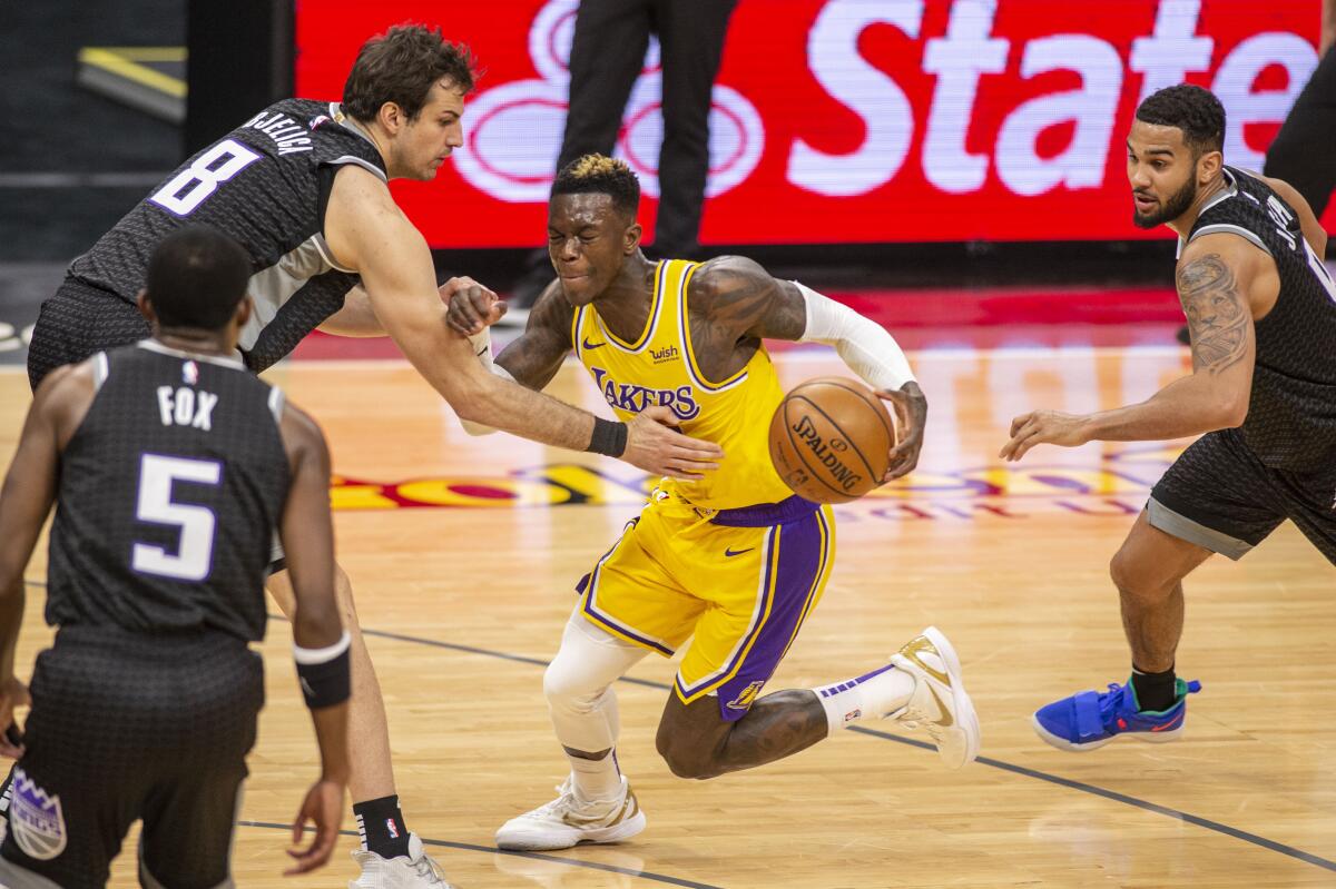 Lakers guard Dennis Schroder drives to the basket in front of Sacramento Kings forward Nemanja Bjelica.