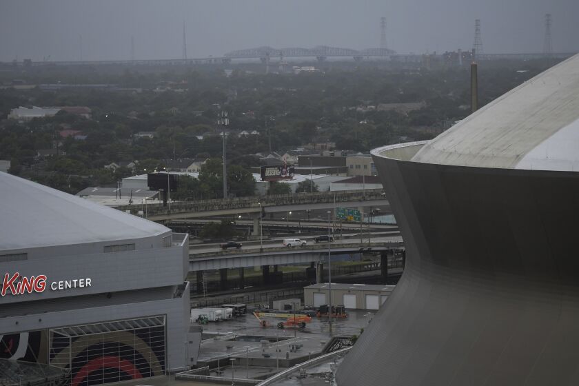 Through the morning rain the Huey P Long Bridge can be seen between the Caesars Superdome and the Smoothie King Center as Hurricane Ida approaches the Louisiana coast in New Orleans, La. Sunday, Aug. 29, 2021. (Max Becherer/The Advocate via AP)