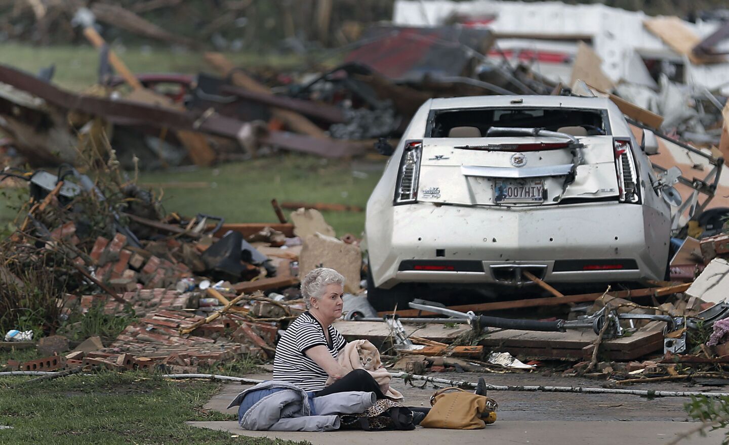 Kay James holds her cat as she sits in her driveway after her home was destroyed by the tornado that hit near Oklahoma City.