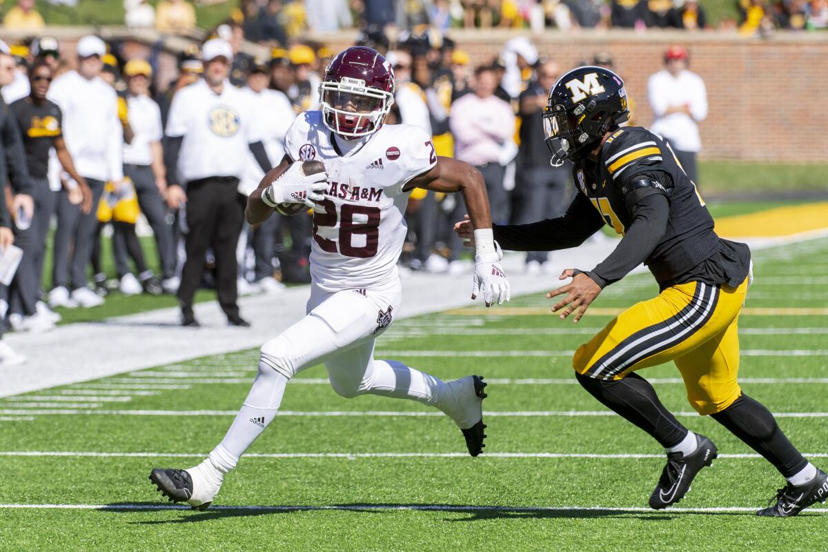 Texas A&M running back Isaiah Spiller runs past Missouri defensive back Shawn Robinson in October.