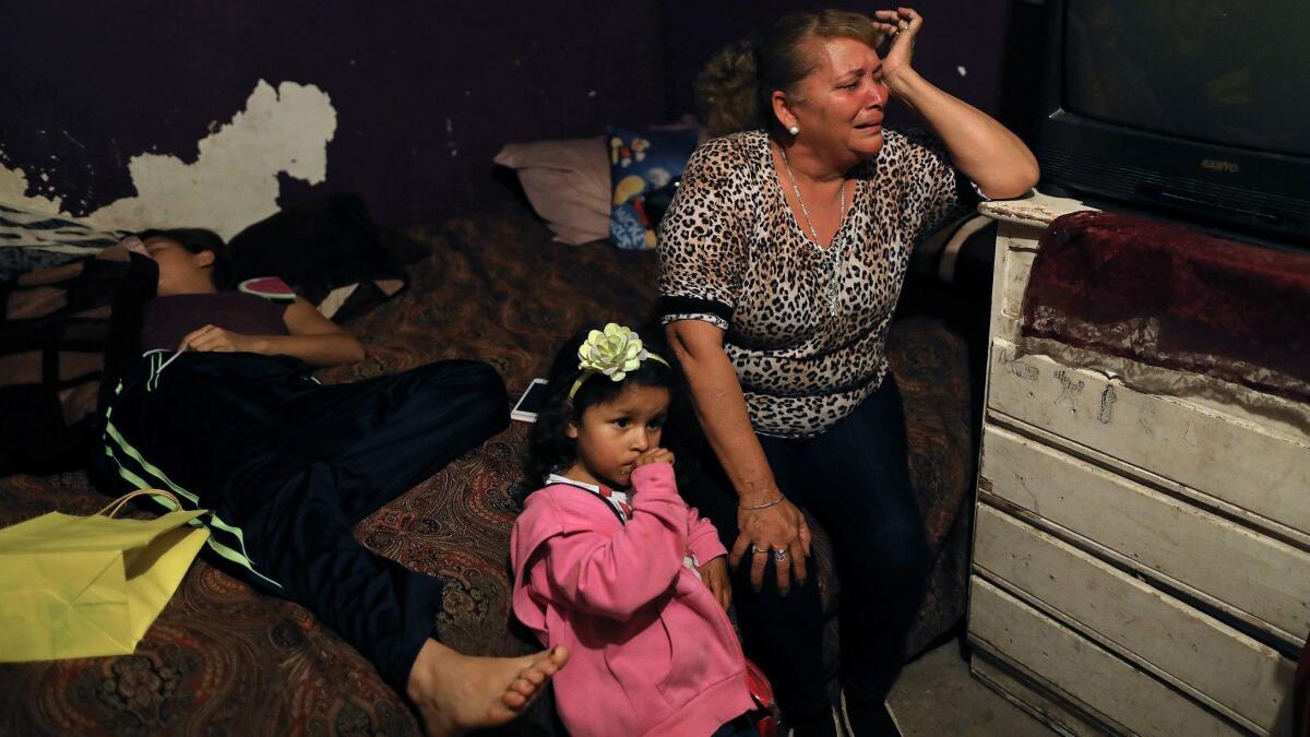 Bertha Peña, shown with granddaughter Michel Noriega, weeps for her son Rafael Noriega Peña, a father of five, who was shot five times.