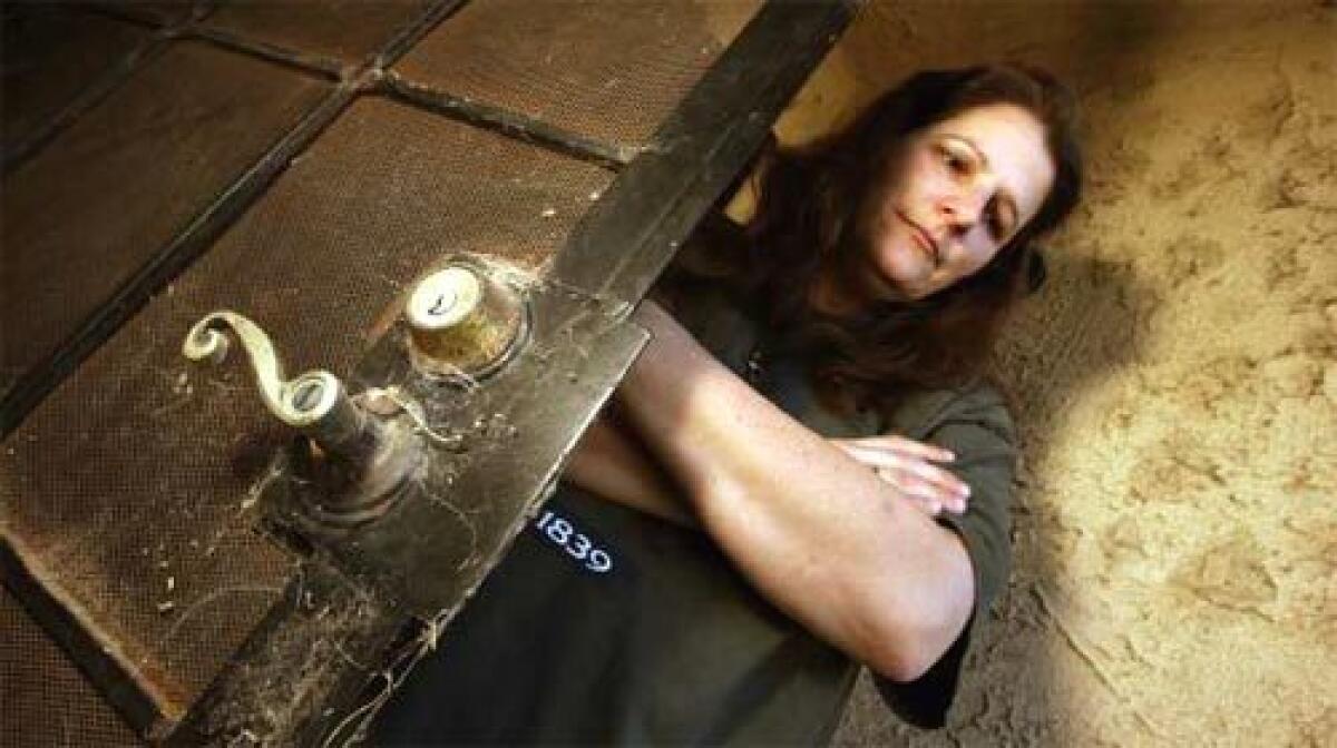 UNSOLD: Rebecca Knowlton stands behind the door of her home. The house, near new Corona developments, has been on the market two years.