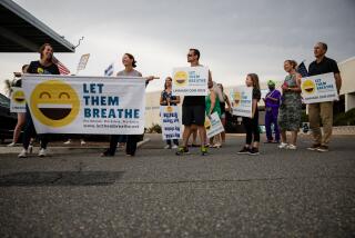 People hold signs protesting face masks in school at the Vista Unified School District 