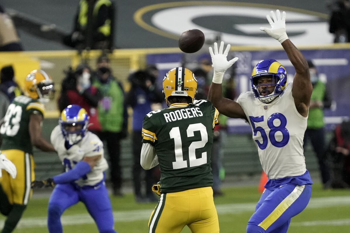 Rams linebacker Justin Hollins tries to block a pass by Green Bay Packers quarterback Aaron Rodgers.
