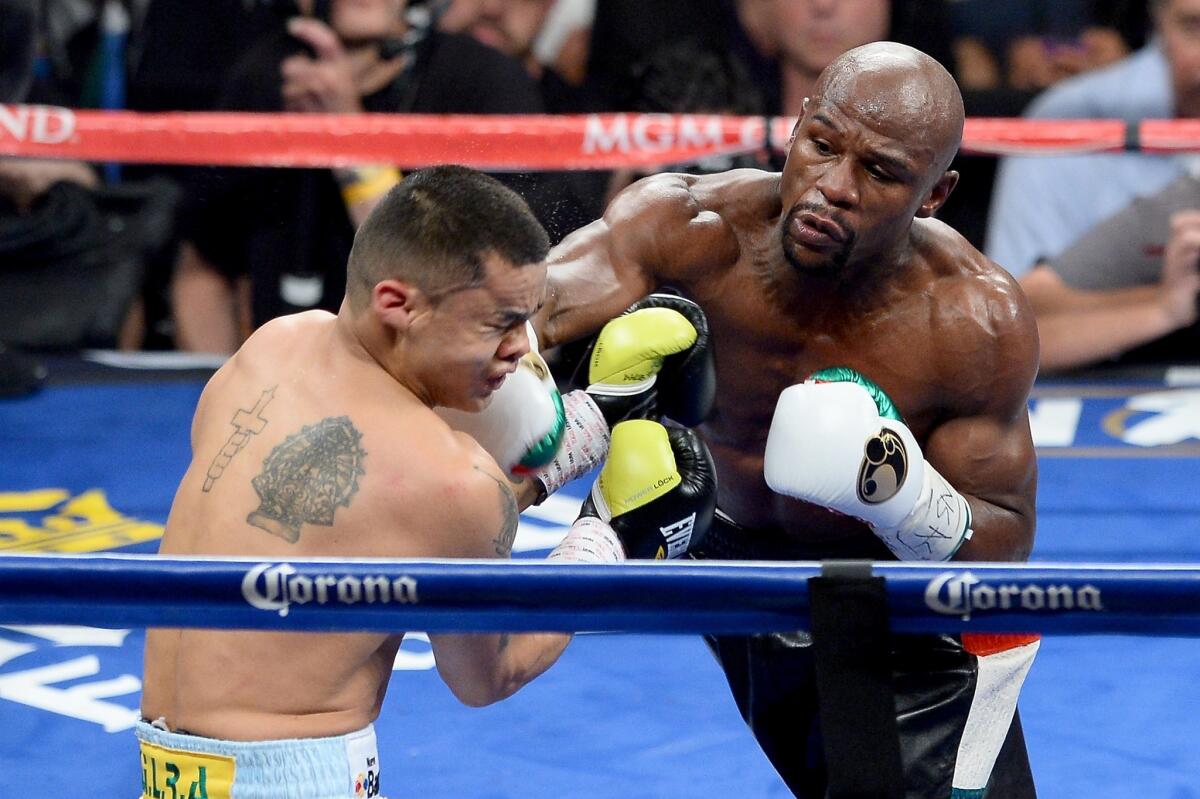 Floyd Mayweather Jr., right, connects on a right punch to the face of Marcos Maidana during their welterweight unification title fight in Las Vegas on Saturday night.