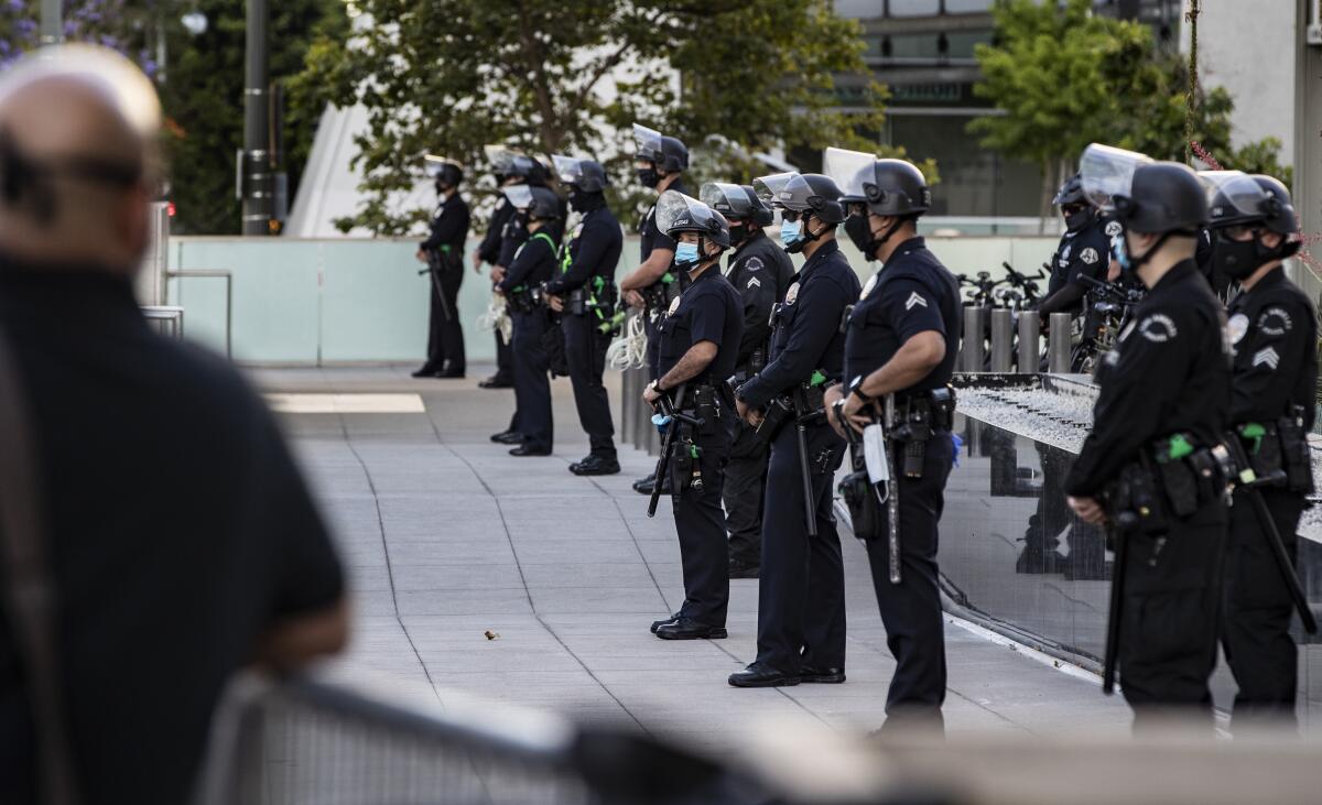 Los Angeles Police officers stand in front of police headquarters to keep Black Lives Matter protesters from advancing.