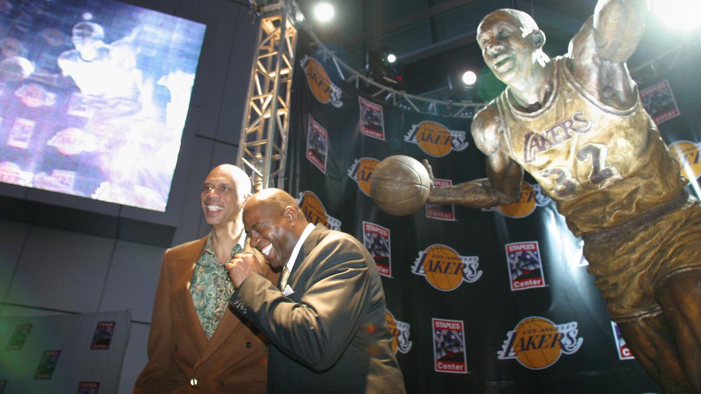 Lakers greats Kareem Abdul Jabbar, left, and Magic Johnson enjoy the moment following the unveiling of a statue of Johnson outside Staples Center.