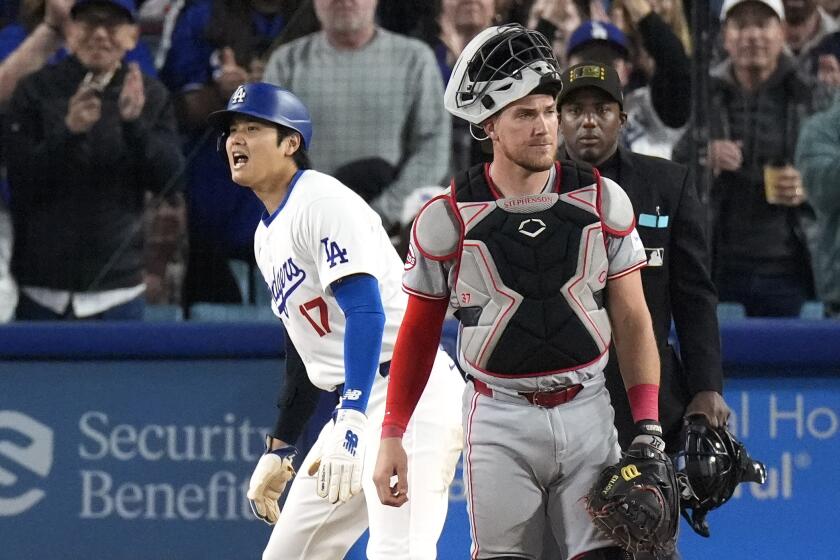 The Dodgers' Shohei Ohtani yells after scoring on a single by Will Smith against the Cincinnati Reds 