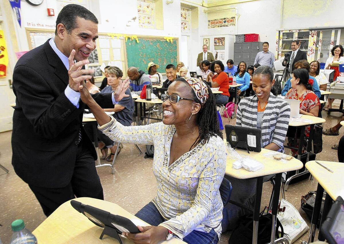 LAUSD Deputy Supt. Jaime Aquino gives a high five to Hillcrest Elementary School teacher Rhonda Marie Smith as teachers attend a iPad training class in 2013. Aquino is no longer with the district.