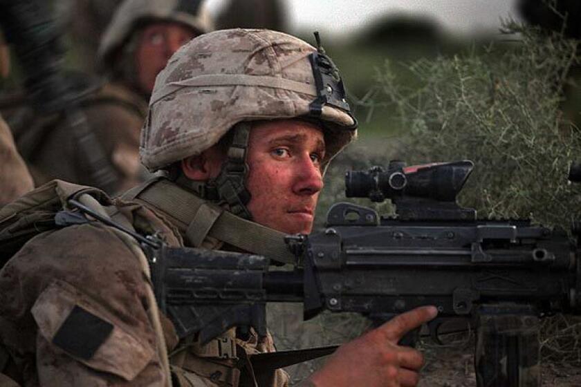 A U.S. Marine with the 2nd Marine Expeditionary Brigade, RCT 2nd Battalion 8th Marines Echo Co. takes up a defensive position after they came under enemy fire on July 17, 2009 in Mian Poshteh, Afghanistan.