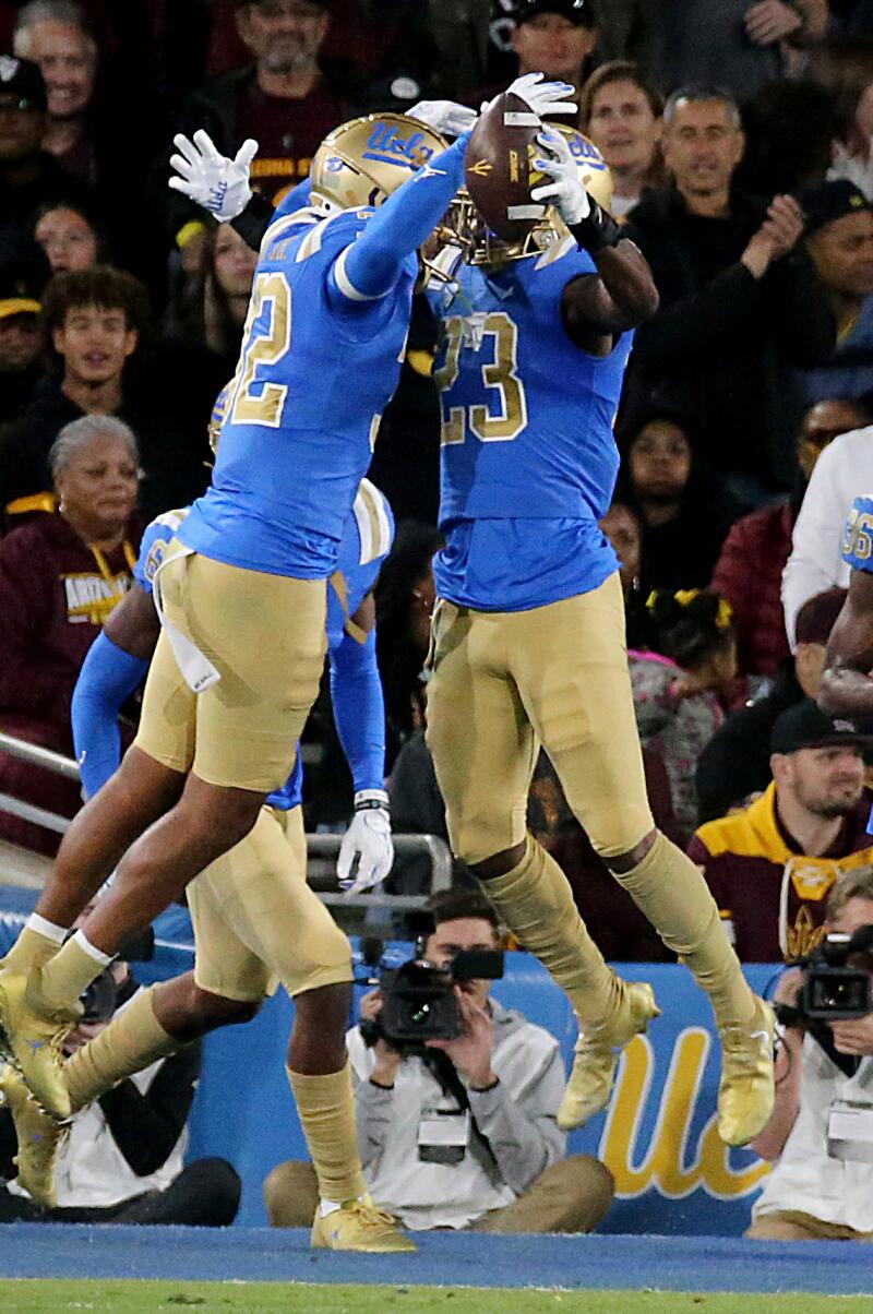 UCLA defensive back Kenny Churchwell III (23) celebrates with a teammate after picking off a pass.