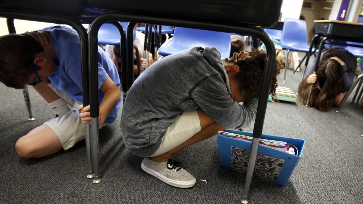 Sixth-graders take cover under their desks at the beginning of an earthquake drill at Pasadena Christian School in 2014.