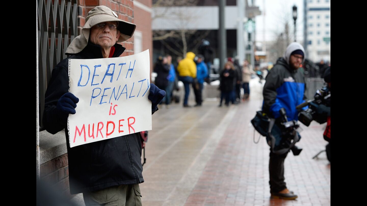 Joe Kebartas holds a sign outside the John Joseph Moakley Federal Courthouse on the opening day of the trial of suspected Boston Marathon bomber Dzhokhar Tsarnaev.