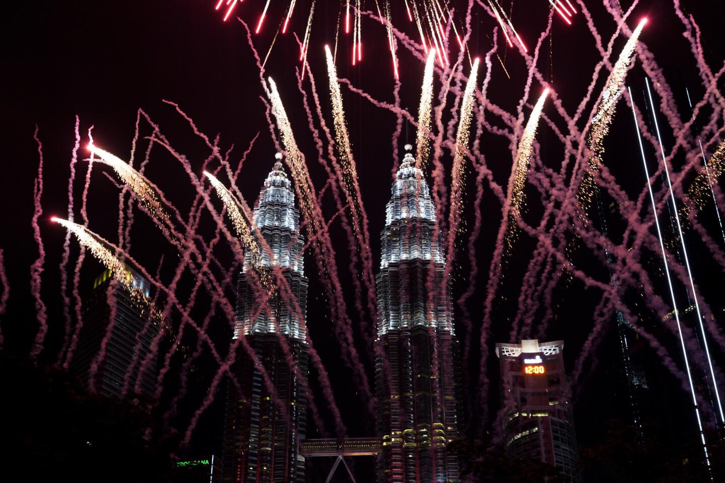 Midnight brings a bright display at the landmark Petronas Towers in Kuala Lumpur, Malaysia.