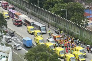Imagen tomada de un video transmitido por TVB de rescatistas asistiendo al lugar en donde cuatro autobuses y un camión chocaron cerca de un túnel vial en Hong Kong, el viernes 24 de marzo e 2023. (TVB vía AP)