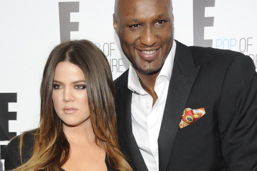 Khloe Kardashian had a strongly worded response on Twitter to those who say she's cashing in on estranged husband Lamar Odom's health scare. The couple is seen here at a 2012 event.