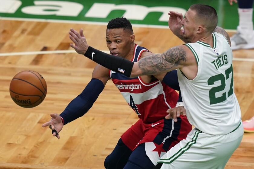 Washington Wizards guard Russell Westbrook (4) passes the ball under pressure from Boston Celtics center Daniel Theis (27) during the first quarter of an NBA basketball game Friday, Jan. 8, 2021, in Boston. (AP Photo/Elise Amendola)