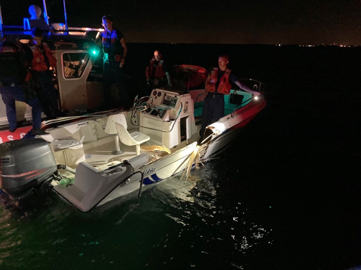 In this image provided by the U.S. Coast Guard, a Coast Guard Station Miami Beach small boat crew inspects a boat that was part of a collision near Key Biscayne, Fla., late Friday, June 17, 2022. The Coast Guard, Miami-Dade Fire Rescue, Miami-Dade Police Department, and Florida Fish and Wildlife crews assisted 10 people and recovered two bodies after their vessels collided. (U.S. Coast Guard via AP)