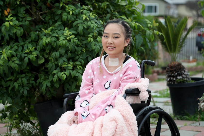 Wynter Ho sits on her wheelchair outside in her garden. 