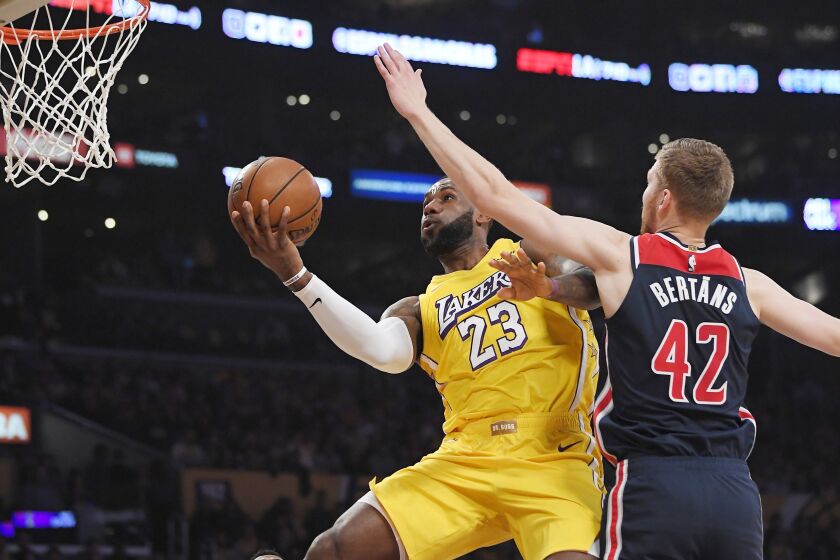 Los Angeles Lakers forward LeBron James, left, shoots as Washington Wizards forward Davis Bertans defends during the first half of an NBA basketball game Friday, Nov. 29, 2019, in Los Angeles. (AP Photo/Mark J. Terrill)