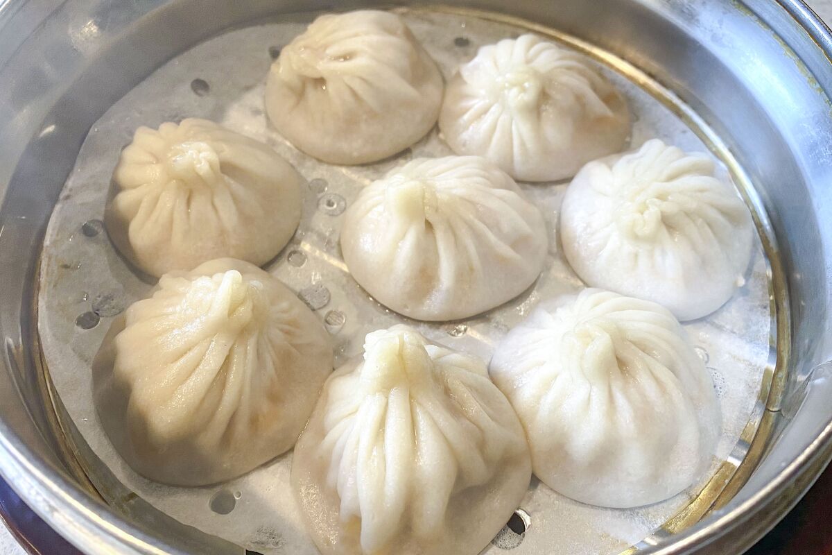 Soup dumplings in a round metal steamer