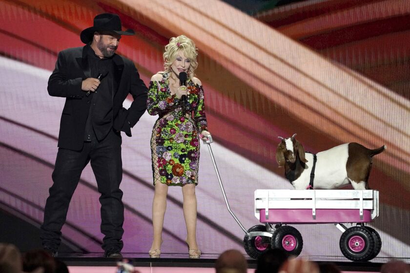 Hosts Garth Brooks, left, and Dolly Parton speak on stage with a goat at the 58th annual Academy of Country Music Awards on Thursday, May 11, 2023, at the Ford Center in Frisco, Texas. (AP Photo/Chris Pizzello)
