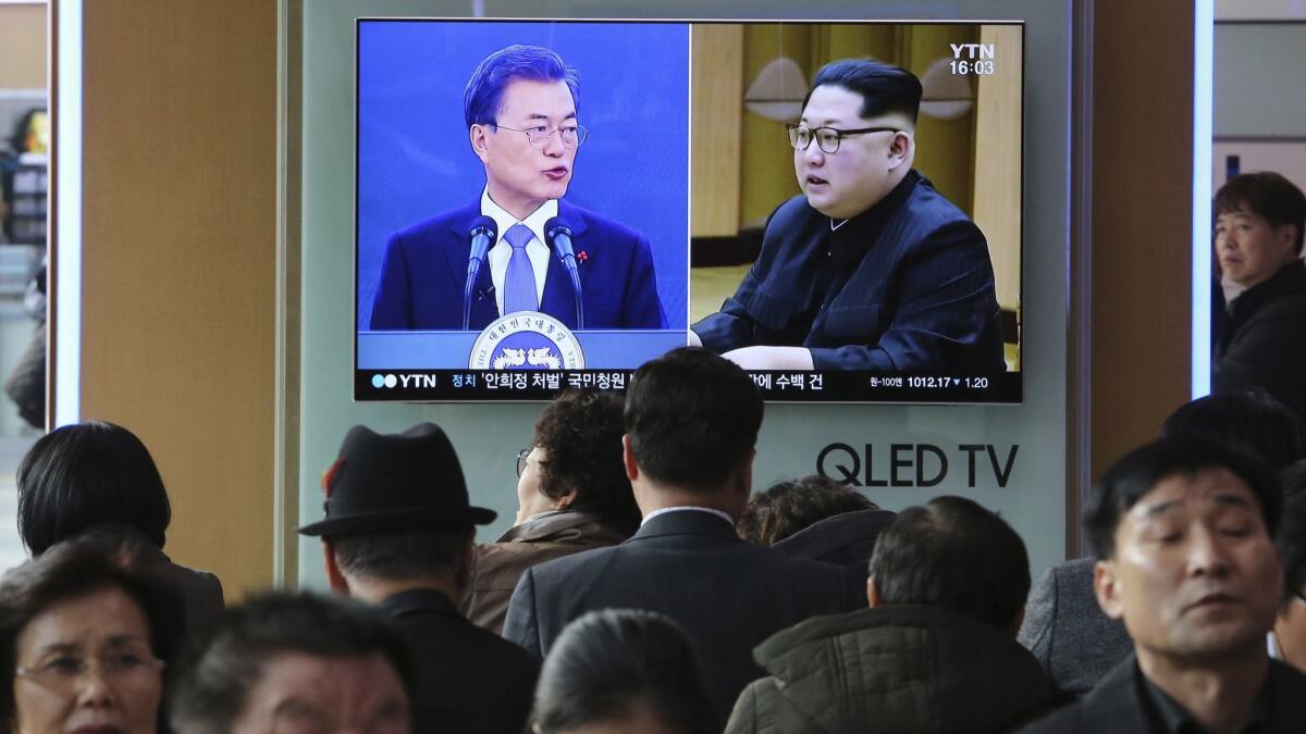 A TV screen on March 7 at a Seoul railway station shows images of South Korean President Moon Jae-in, left, and North Korean leader Kim Jong Un.
