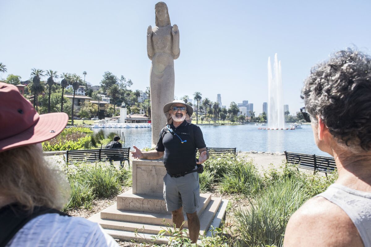 Stair tour leader Dan Gutierrez talks about the history of the Queen of the Angels statue at Echo Park Lake during a 15-mile guided walking tour.