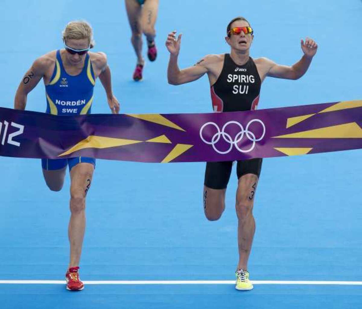 Silver medalist Sweden's Lisa Norden, left, and gold medalist Switzerland's Nicola Spirig cross the finish line.