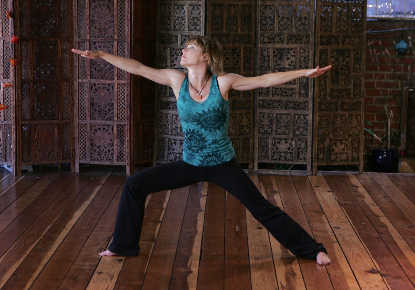 Legs are as in Warrior I, but the arms are outstretched at the sides, perpendicular to the sides of the body. Don't: Let the shoulders rise toward the ears. The shoulders are a common place to hold tension, and people sometimes tend to let them move up when they're tired. But holding the shoulders up can shorten the trapezius muscle (which extends from the base of the skull across the shoulders and down the back) and can cause a bit of spasming.