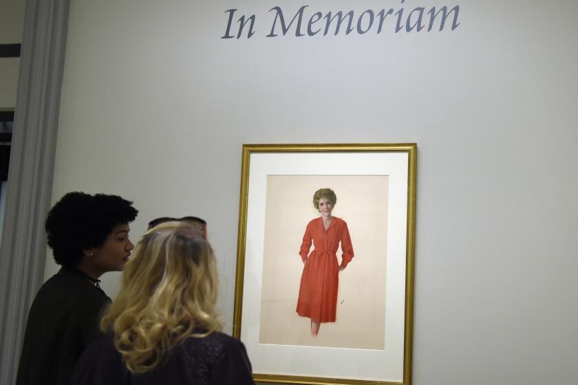 Visitors at the National Portrait Gallery in Washington look at a portrait of former first lady Nancy Reagan.