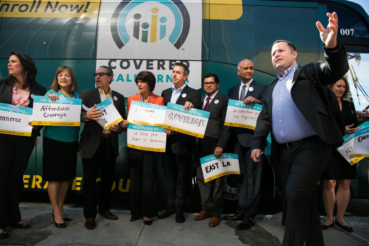 Covered California Executive Director Peter V. Lee, center, gathers with local lawmakers at an open enrollment event in 2015.