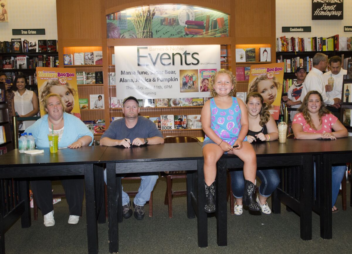 The cast of "Here Comes Honey Boo" sits at a long table in a bookstore