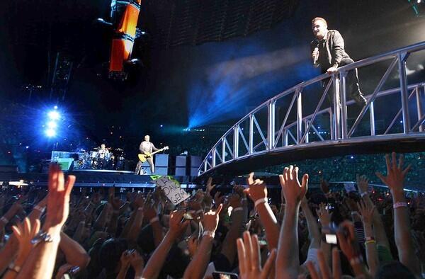 Bono gets close to the fans, thanks to the band's four-legged circular stage rig known as the Claw, or the Space Station.